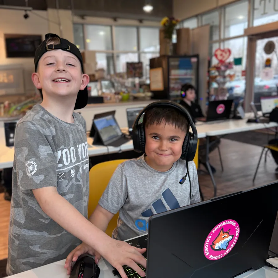 Kids smiling while coding together